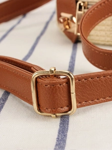 Brown lychee grain leather strap with gold metal buckle detail on a woven bag