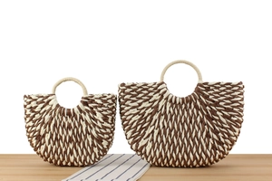 Detail of woven straw handbags in two sizes with brown and cream V-shaped patterns