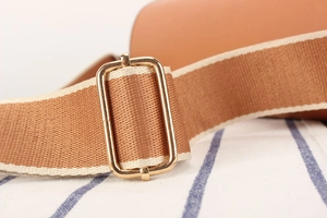 Detail of contrast color woven strap with premium golden adjustable metal buckle