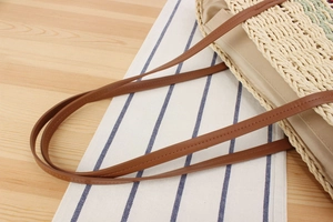 Close-up of woven paper rope bag with brown faux leather strap and durable inner lining