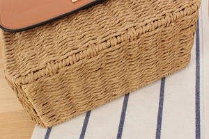 Detailed view of handwoven paper rope bag featuring a premium brown leather flap cover