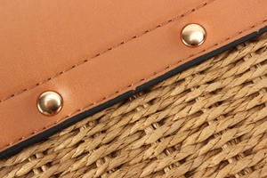 Close-up of premium leather stitching and natural woven straw texture on fashion bag