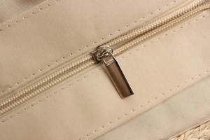 Close-up of the metal zipper and neat stitching on a paper rope woven bag