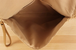 Detail view of woven paper rope bag interior with fabric lining and open slip pocket