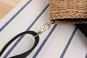 Vue détaillée de la texture du sac en corde de papier avec bandoulière noire et boucle métal
