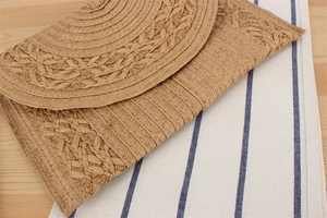 Detailed close-up of handmade paper rope woven envelope bag with wavy bohemian patterns