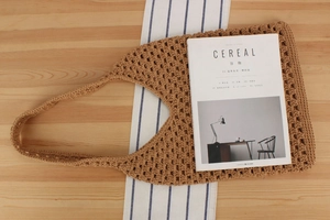Sac fourre-tout en crochet kaki avec motifs ajourés sur une nappe rayée de style