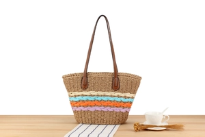 Macro detail of large woven paper straw tote with vibrant four-color striped patterns