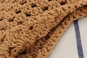 Gros plan sur le motif de crochet évidé marron et le tissage en coton d'un sac cabas