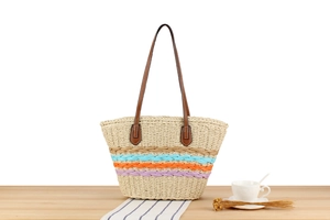 Detail of hollow paper rope woven tote bag with colorful stripes and leather shoulder straps