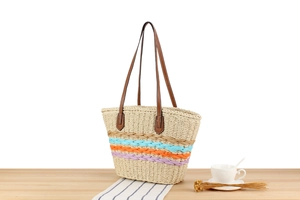 Detail of handwoven paper rope tote with colorful stripes and brown leather straps