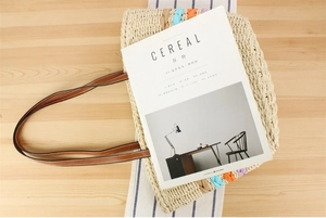 Detail of hollow paper rope woven tote with colorful fabric accents and slim handles