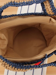 Navy and beige woven straw tote bag with fabric lining and interior zipper pocket