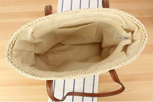 Interior view of straw beach bag showing beige lining with functional inner pocket