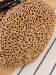 Minimalist hand-woven straw bag with a contrast smiley design and circular woven texture