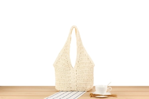 Gros plan sur la texture crochetée blanc cassé du grand sac cabas tissé ajouré