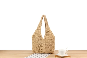 Vue détaillée du sac à bandoulière en paille tressée avec texture artisanale marron naturel