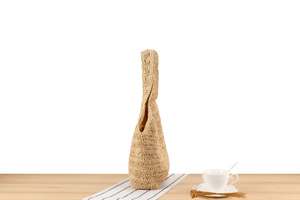 Détail d'un sac hobo en paille tressé à la main avec texture crochet et poignée intégrée