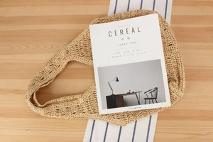 Vue de dessus détaillée d'un sac cabas en paille tressée sur une table en bois d'été