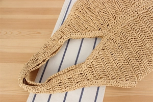 Gros plan sur la texture tissée ajourée d'un sac à main d'été en paille beige clair