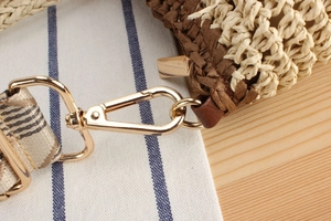 Macro shot of two-tone paper rope weaving texture with golden metal lobster clasp