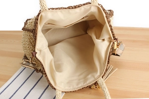 Top view of woven tote interior with fabric lining, zipper pocket, and striped strap