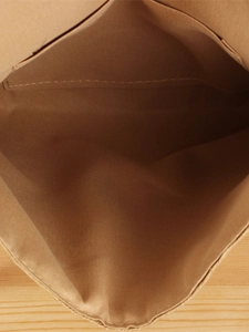 Interior detail of a woven paper rope crossbody bag with lining and inner pocket