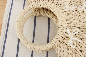 Dettaglio di borsa da spiaggia in corda di carta beige con fiocco di perle bianche