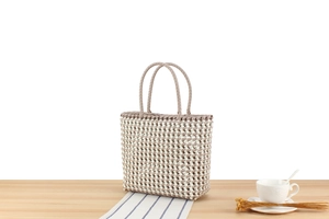 Détail du sac cabas en PVC tissé à la main avec rayures beiges et blanches
