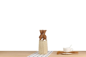Detail of woven straw bucket bag with twisted brown leather handle and inner lining