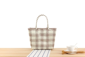 Detail of checkered PVC woven tote bag showing beige and taupe flexible texture