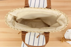 Interior view of woven tote bag showing white fabric lining and zippered pocket details