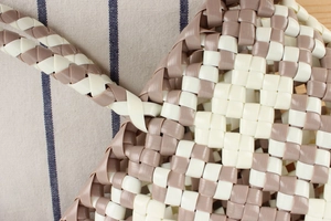 Close-up of hand-woven PVC shopper bag featuring checkered pattern and braided handles