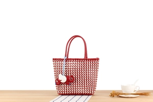 Detailed texture of red and white woven tote bag with a cute elephant charm