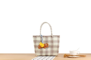 Close-up of woven checkered tote bag in purple and white with a cute elephant charm
