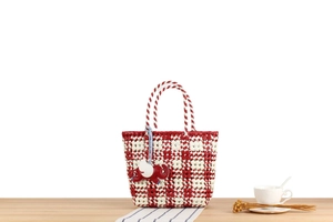 Detail of red and white checkered woven tote bag featuring a cute elephant charm