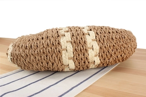 Detail of hand-woven straw tote bag with brown and beige stripes on wooden surface