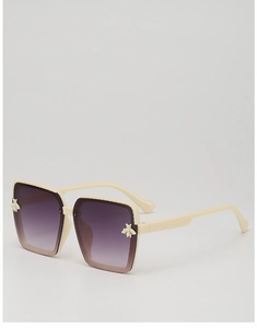 Detail view of cream resin square frame with bee emblem and diamond textured temples