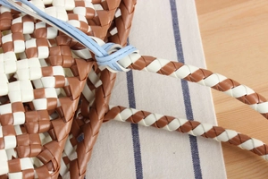 Close-up of woven checkered pattern and light blue strap on casual tote bag