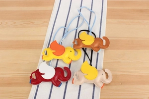 Detail of four colorful leather flying elephant bag charms with neat stitching and lanyards