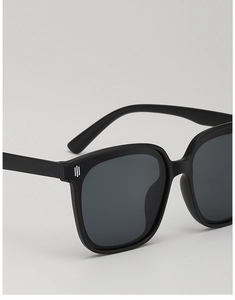 Close-up of matte black kids sunglasses with silver metal detail on the temple