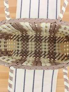 Handwoven PVC tote bag with cream and brown checkered pattern in a spacious top view