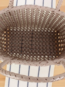 Sac cabas tressé en PVC taupe avec anses rondes vue de dessus sur table en bois