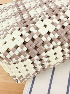 Handwoven PVC basket bag featuring grey and white checkered pattern on a wooden background