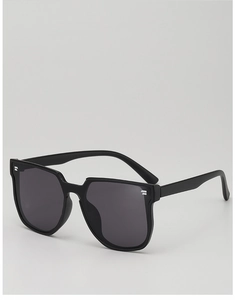 Close-up of black oversized kids sunglasses with silver metal accents on the frame side