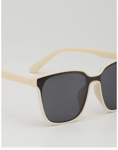 Detailed side view of cream-colored oversized kids sunglasses with dark polarized lenses