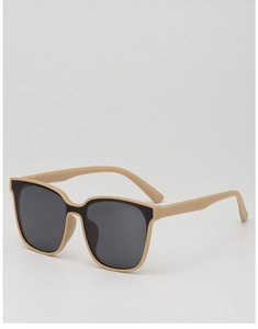 Detailed side view of stylish beige oversized children sunglasses with dark lenses