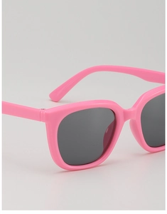 Close-up of vibrant pink kids' sunglasses with UV-protection lenses and polished finish