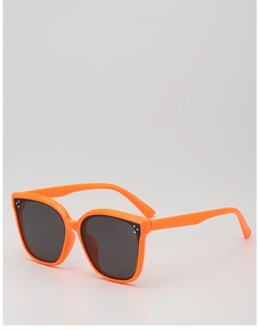 Close-up of bright orange plastic sunglasses frame with decorative triple dot details