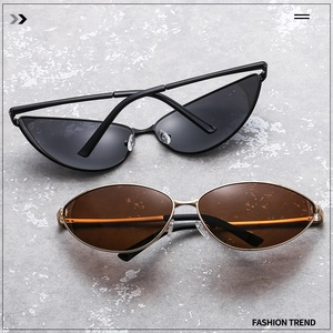 Close-up of black cat-eye and golden oval metal sunglasses on a textured grey stone surface